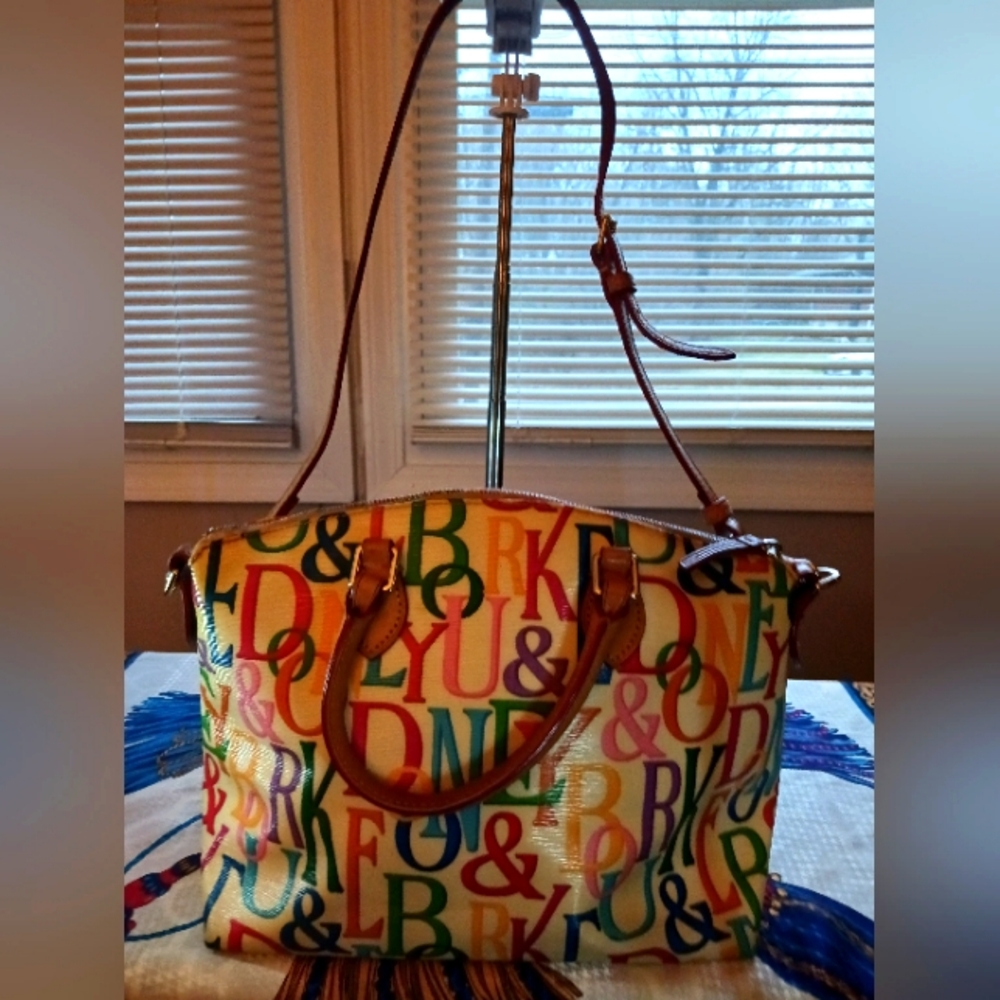 Rainbow colored Dooney & Bourke bag with white background.
